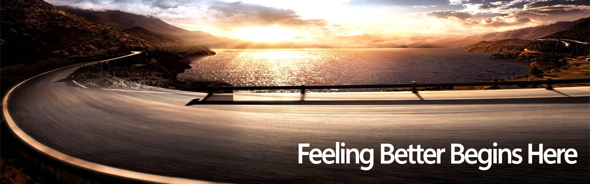 A curving road beside a sunlit lake at sunset, with the words “Feeling Better Begins Here.”
